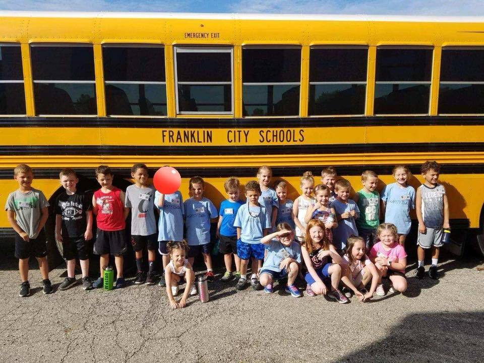kids in front of School Bus